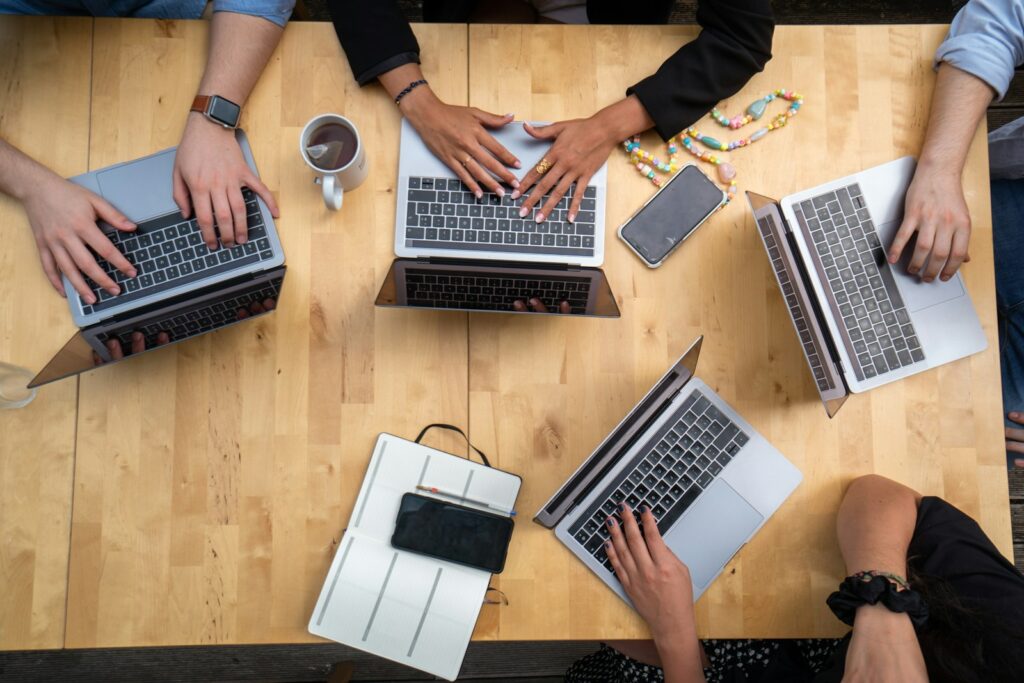 fractional project manager using laptop on brown wooden table during meeting